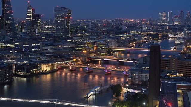 Лондонские мосты подсвечиваются вдоль Темзы ночью вместе с горизонтом. 