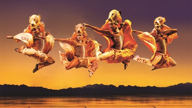 Четыре танцора прыгают через сцену в костюмах львов в фильме «Король Лев».